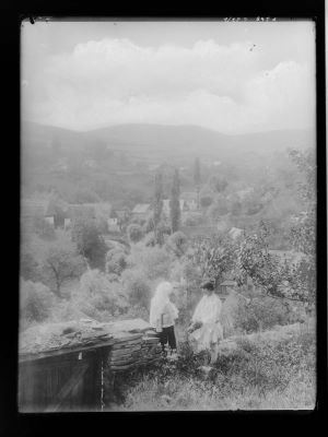 clișeu - Emil Fischer; Vedere asupra unui sat din Mărginimea Sibiului, cu o pereche de țărani în prim plan.