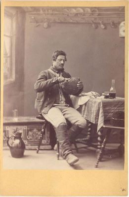 fotografie - Theodor Glatz; Bărbat sas din Cisnădioara în costum de muncă așezat la masă