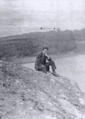 fotografie; Tânărul Ștefan Procopiu șezând pe o colină, la malul unei ape